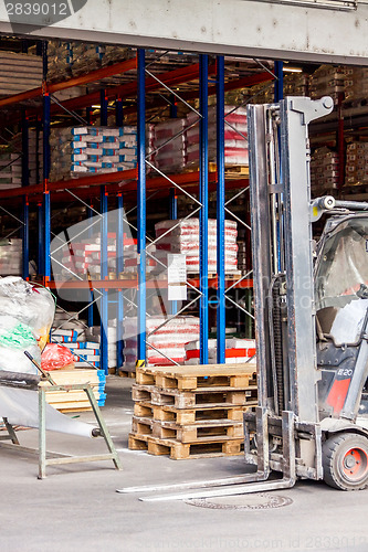 Image of Small orange forklift parked at a warehouse