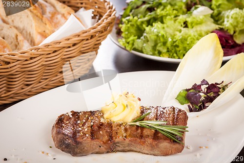 Image of Grilled beef steak topped with butter and rosemary