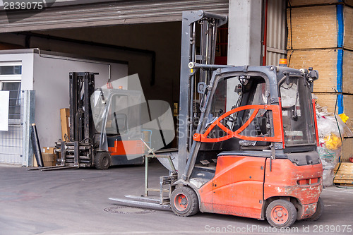 Image of Small orange forklift parked at a warehouse