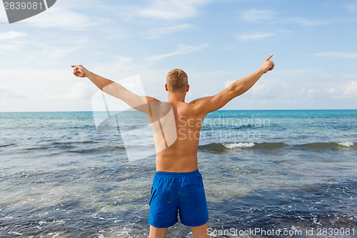 Image of Man in blue swim shorts in the beach