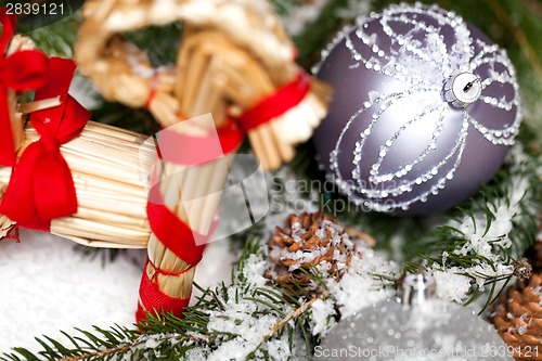 Image of Silver Christmas bauble on a tree with snow