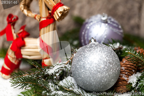 Image of Silver Christmas bauble on a tree with snow