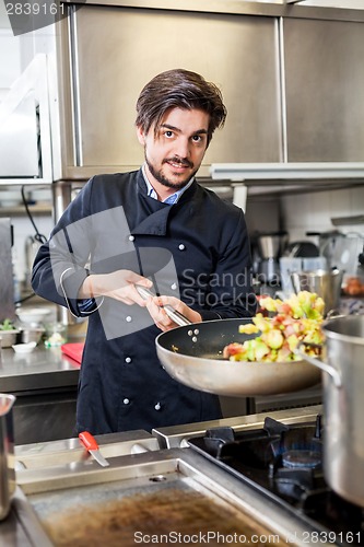 Image of Chef cooking a vegetables stir fry over a hob