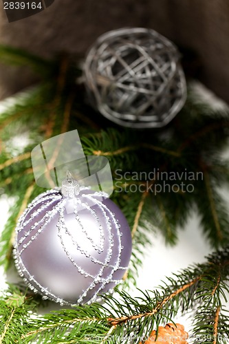 Image of Silver Christmas ornaments in leaves