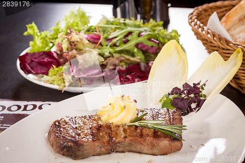 Image of Grilled beef steak topped with butter and rosemary