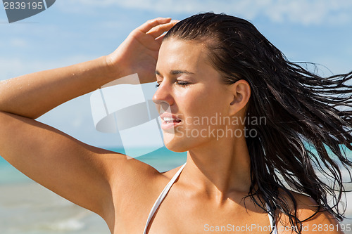 Image of Young woman looking far away in the beach