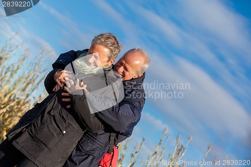 Image of Elderly couple embracing and celebrating the sun