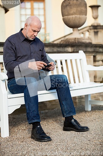 Image of Man checking a photo on his mobile phone