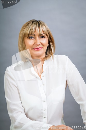 Image of Smiling confident middle-aged blond woman