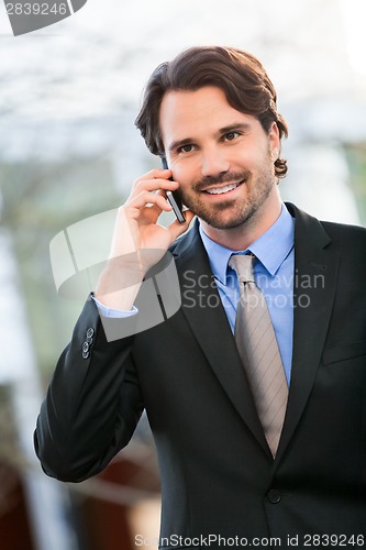 Image of Businessman listening to a call on his mobile