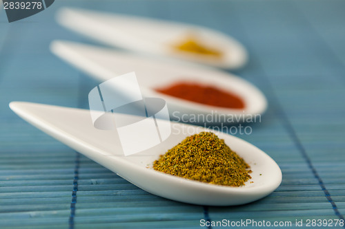 Image of Dried ground spices in ceramic spoons