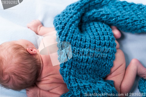 Image of Small infant wrapped in knitted fabric