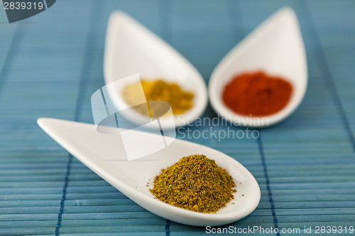 Image of Dried ground spices in ceramic spoons