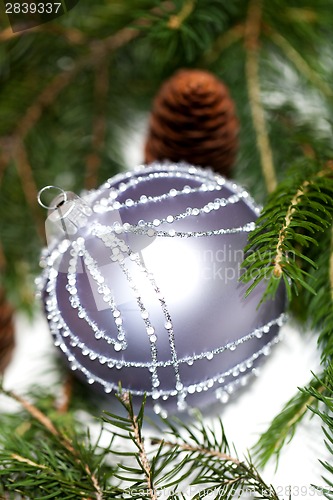 Image of Silver Christmas ornaments in leaves