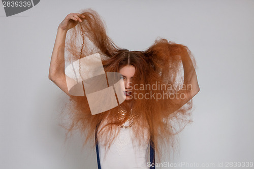 Image of Female model playing with frizzy hair