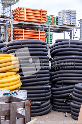 Image of Rolls of plastic pipes in a warehouse yard