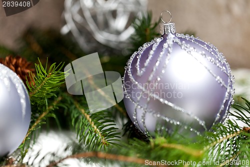 Image of Silver Christmas ornaments in leaves