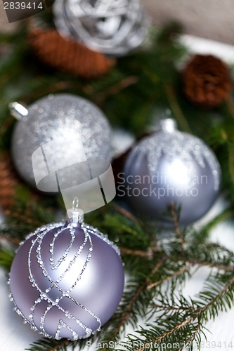 Image of Silver Christmas ornaments in leaves