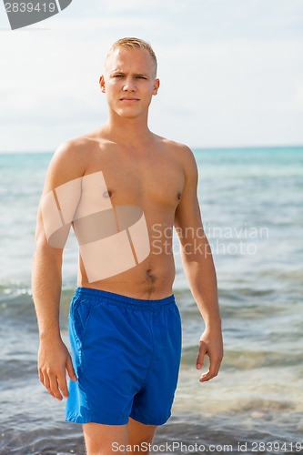 Image of Man in blue swim shorts in the beach