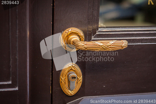 Image of Brass door handle on a colorful blue door