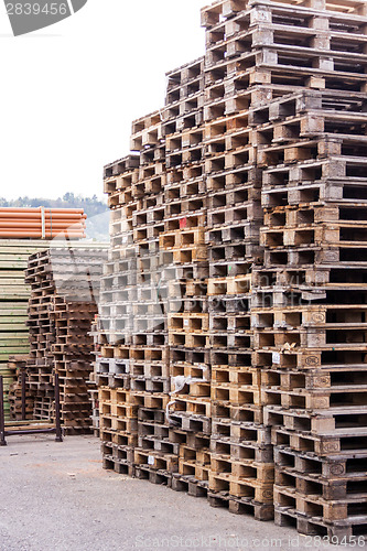 Image of Stacks of old wooden pallets in a yard