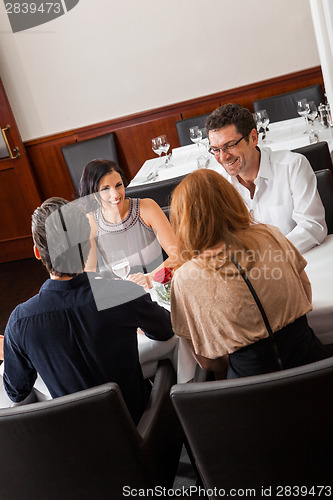 Image of Waiter happily accommodating couple