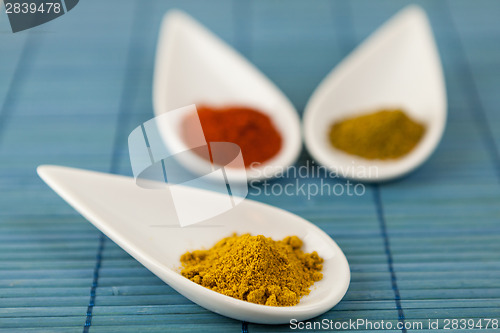 Image of Dried ground spices in ceramic spoons