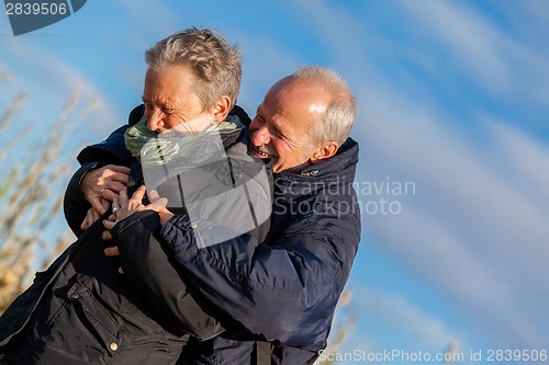 Image of Elderly couple embracing and celebrating the sun