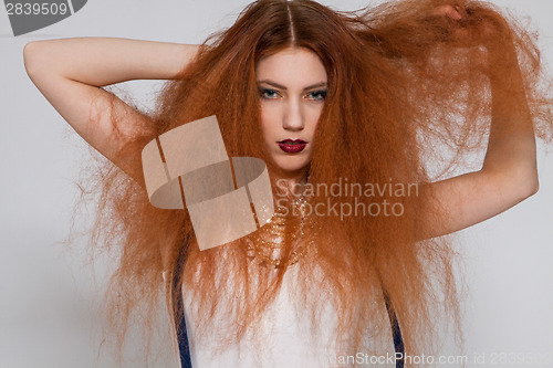 Image of Female model playing with frizzy hair