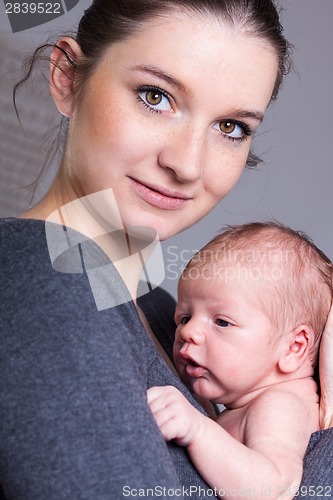 Image of Young mother carrying infant