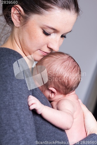 Image of Young mother carrying infant