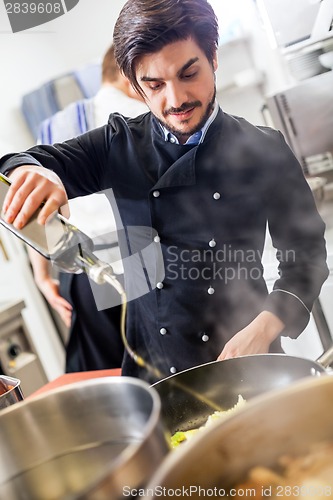 Image of Chef cooking a vegetables stir fry over a hob