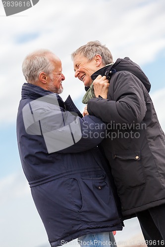 Image of happy elderly senior couple walking on beach