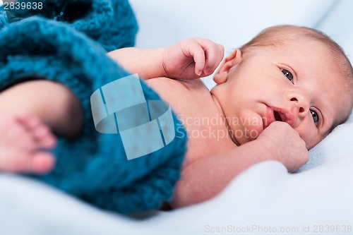 Image of Small infant wrapped in knitted fabric