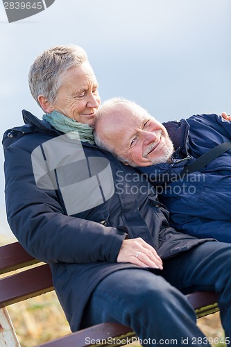 Image of happy senior couple relaxing together in the sunshine