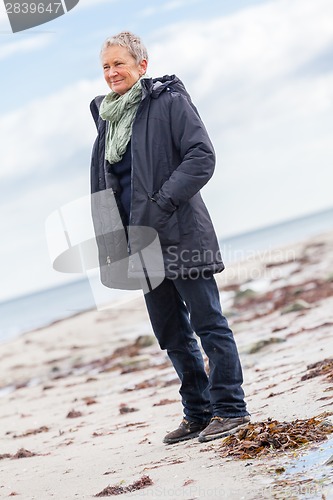 Image of happy elderly senior couple walking on beach