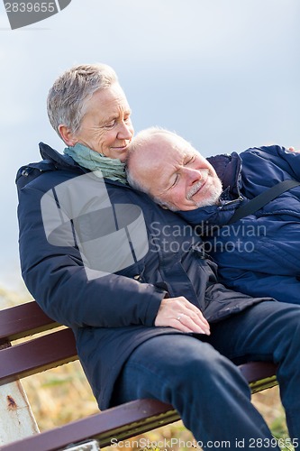 Image of happy senior couple relaxing together in the sunshine