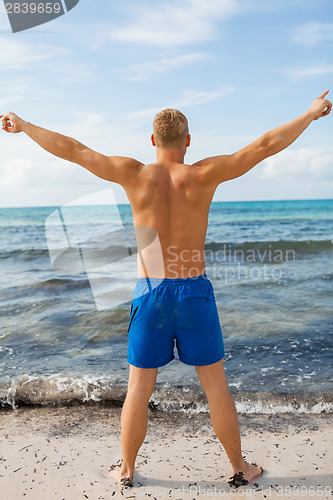 Image of Man in blue swim shorts in the beach