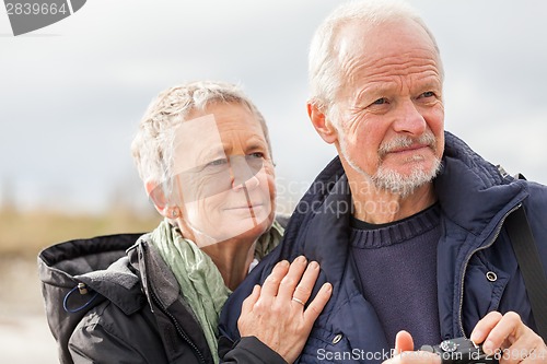 Image of happy elderly senior couple walking on beach