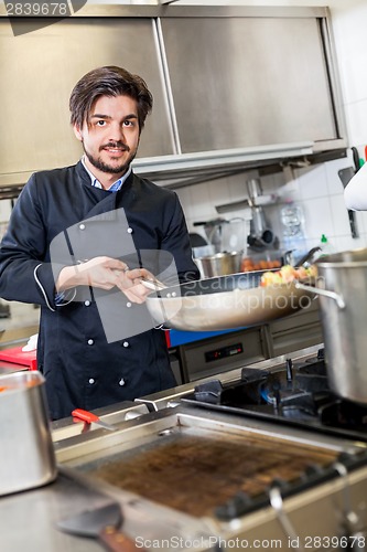 Image of Chef cooking a vegetables stir fry over a hob