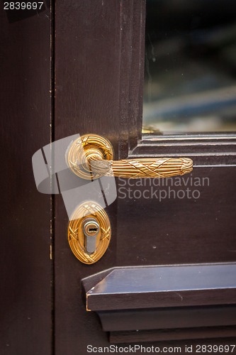 Image of Brass door handle on a colorful blue door