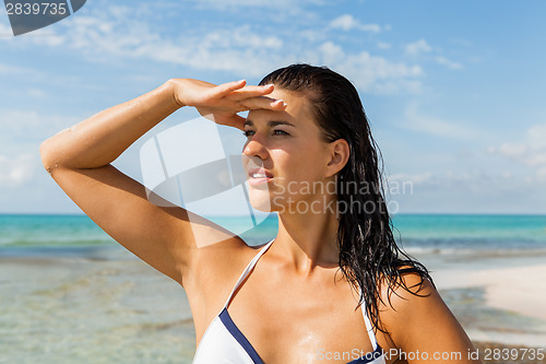 Image of Young woman looking far away in the beach