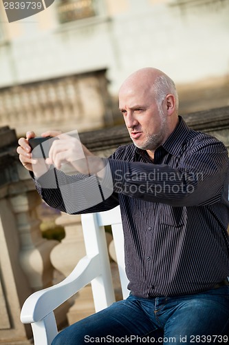 Image of Man taking a photograph with his mobile