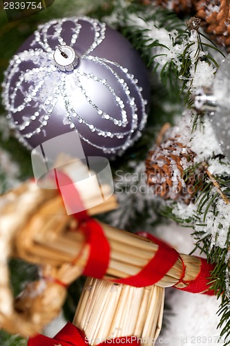 Image of Silver Christmas bauble on a tree with snow