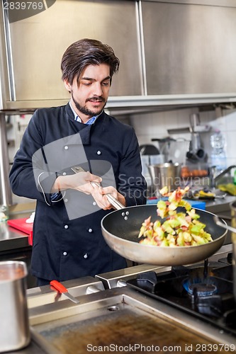 Image of Chef cooking a vegetables stir fry over a hob