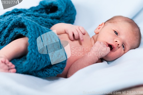 Image of Small infant wrapped in knitted fabric