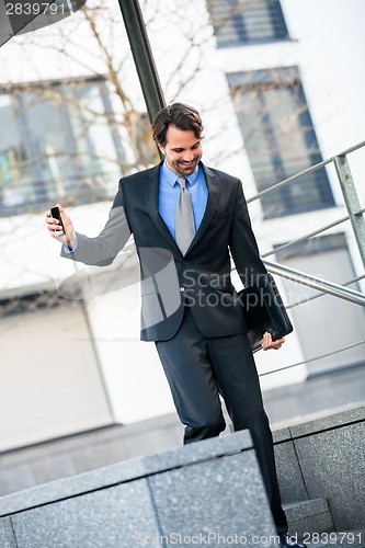 Image of Smiling businessman walking down stairs