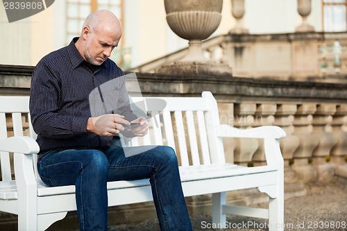 Image of Man checking a photo on his mobile phone