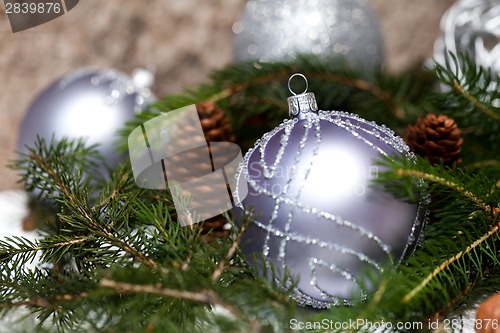 Image of Silver Christmas ornaments in leaves