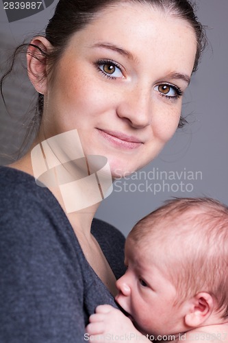 Image of Young mother carrying infant